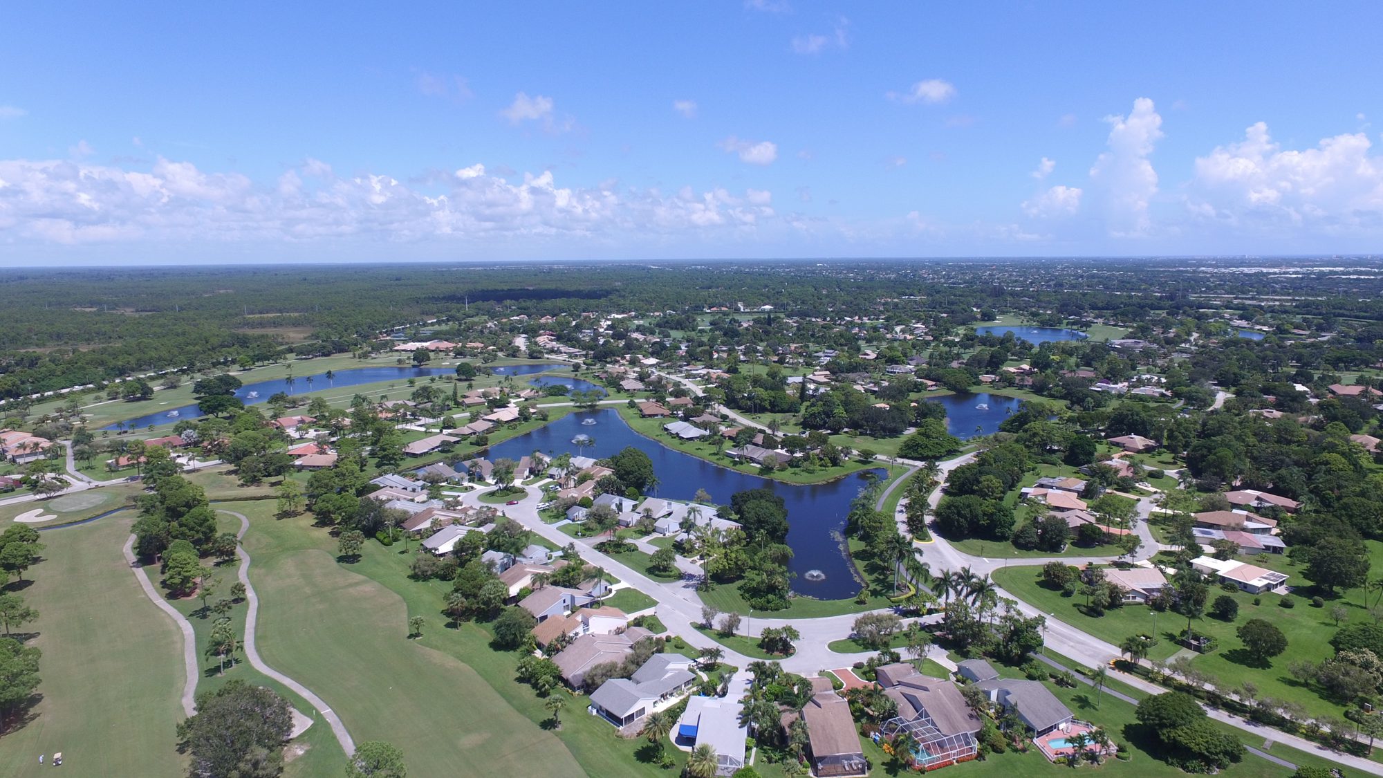 The clubhouse, tennis courts and island green from above