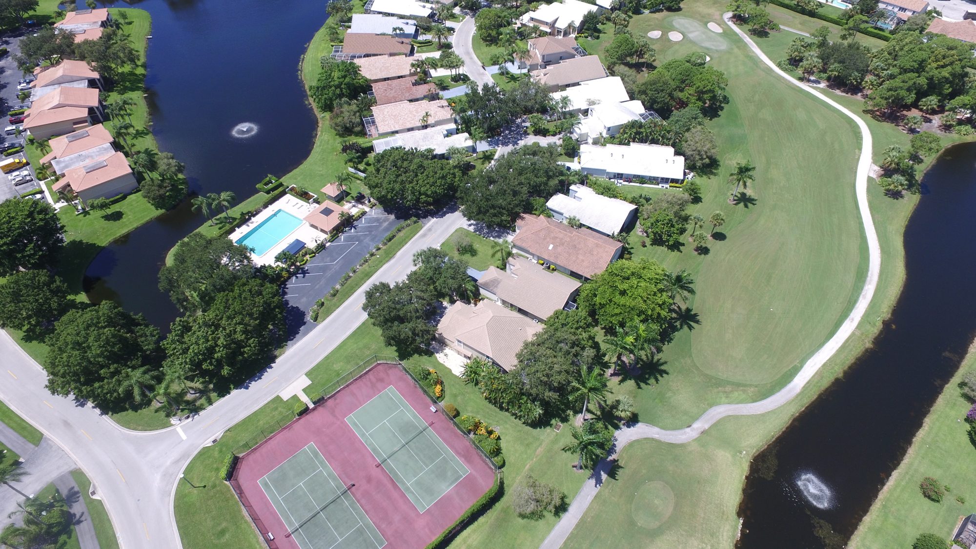 A neighborhood pool and tennis courts beside an East Point fairway