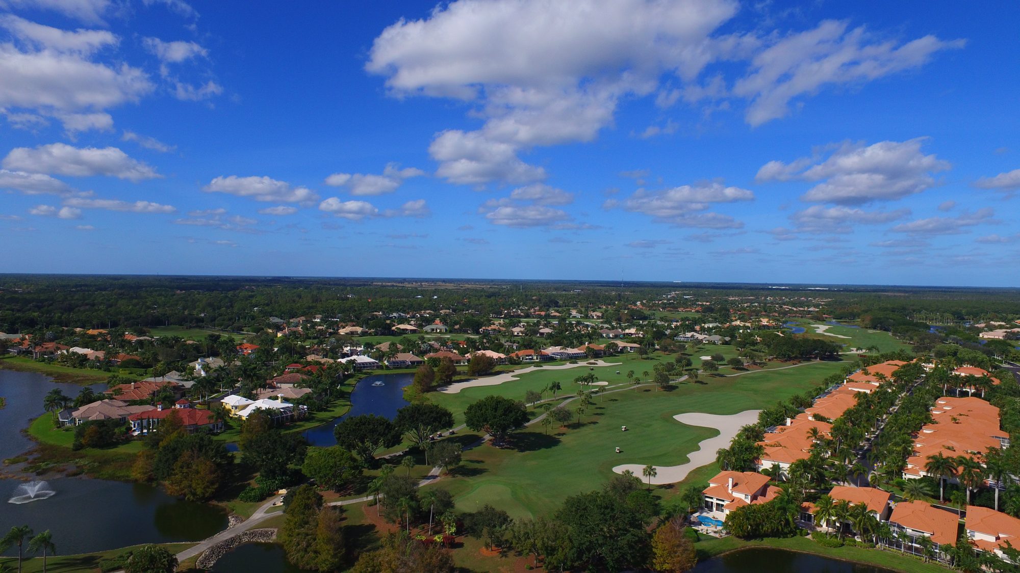 Aerial view of an Ibis fairway with large white bunkers, lakes and homes