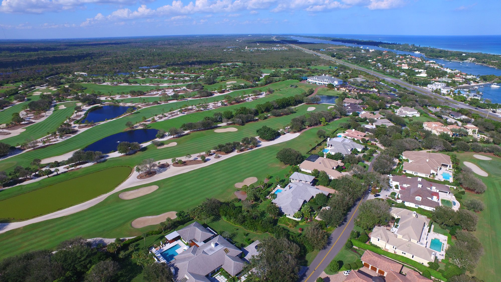 A Jupiter Hills fairway with the Jupiter Inlet and the Atlantic beyond