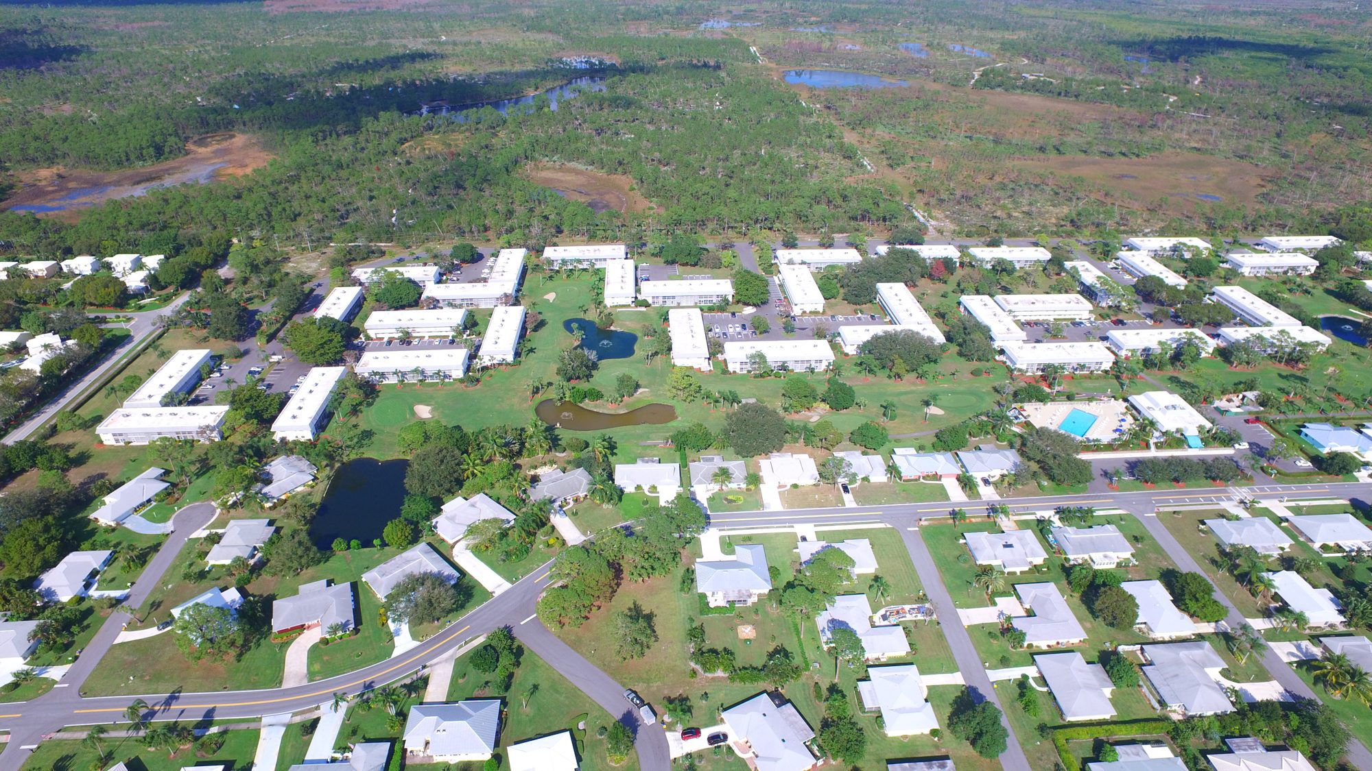 Little Club homes, condominiums and the tennis court under a blue sky