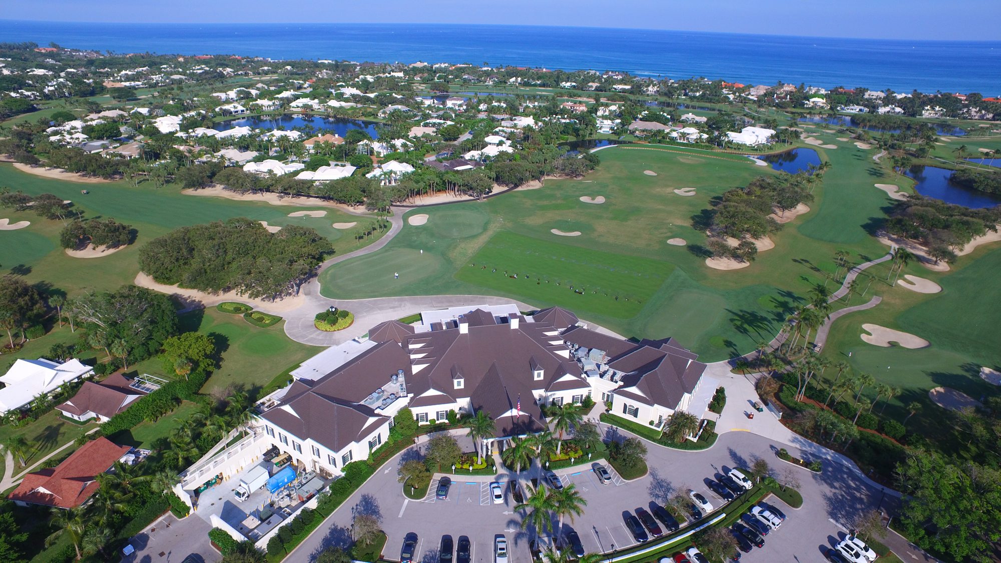 The Lost Tree clubhouse and practice range with the ocean beyond