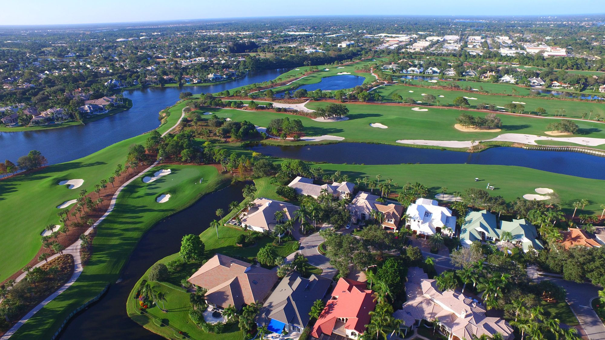 An island green beside waterfront homes at The Loxahatchee Club