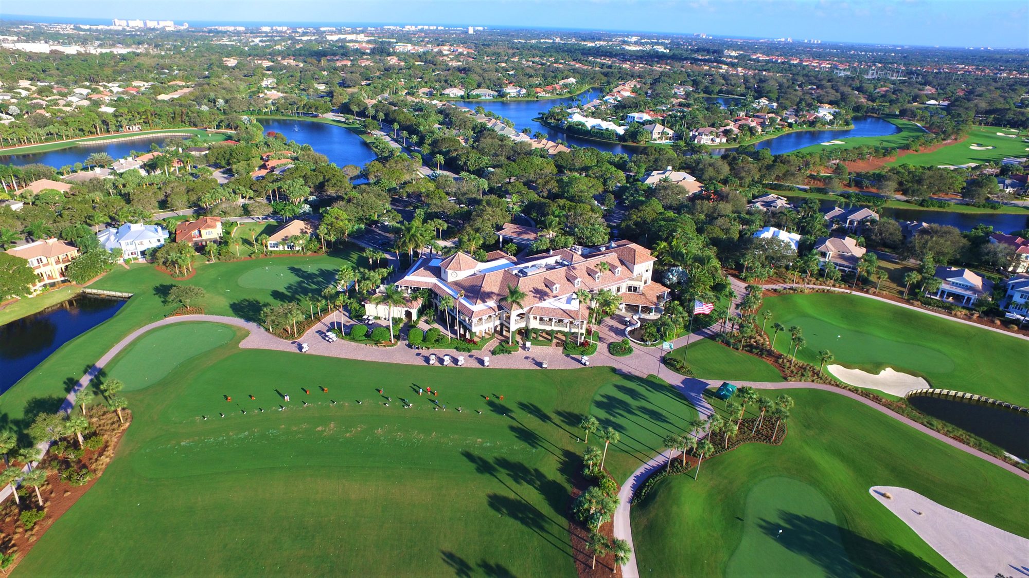 Two Loxahatchee Club greens framed by lakes, palms and bunkers