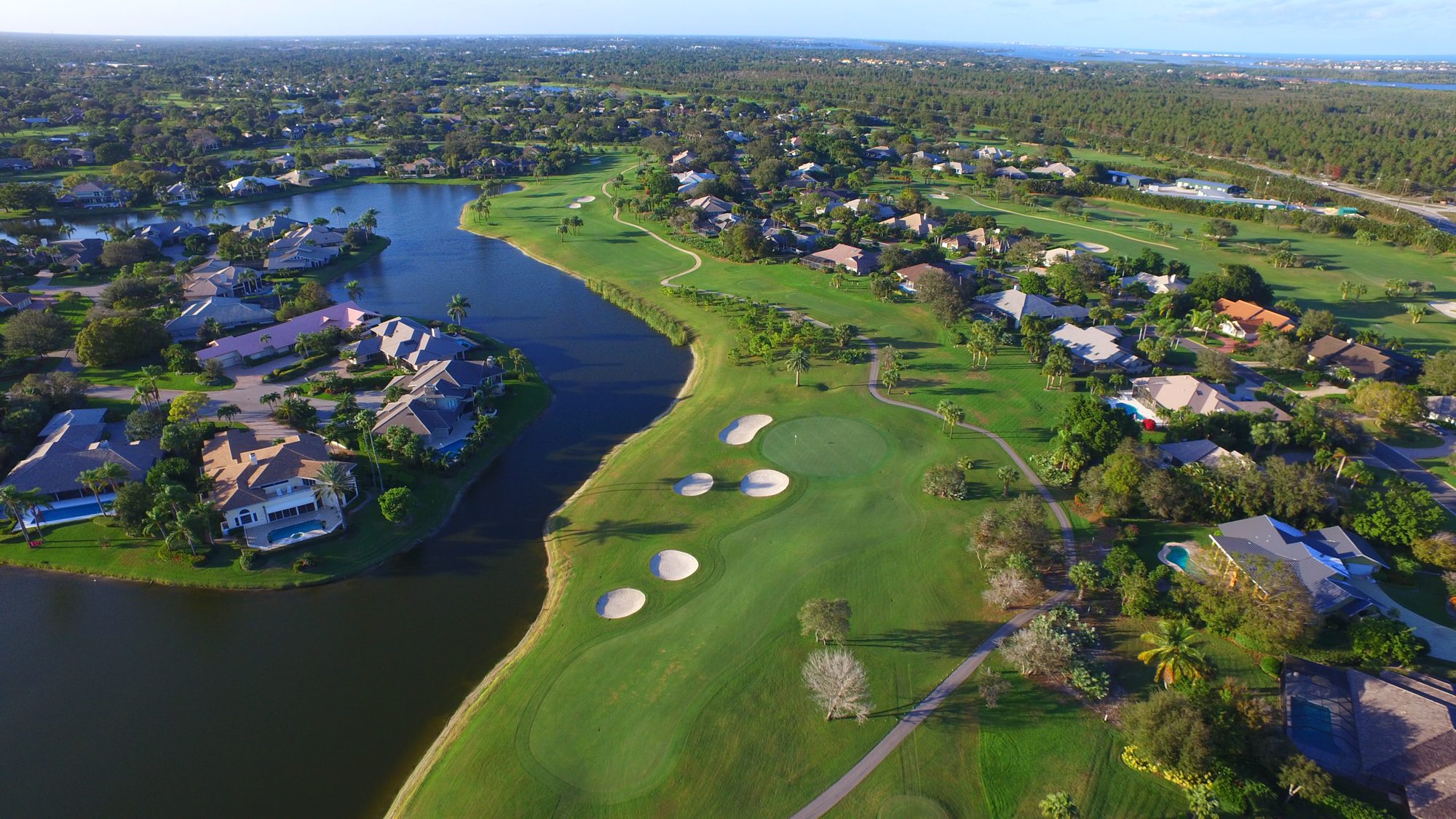 A Mariner Sands green along a lake lined with homes