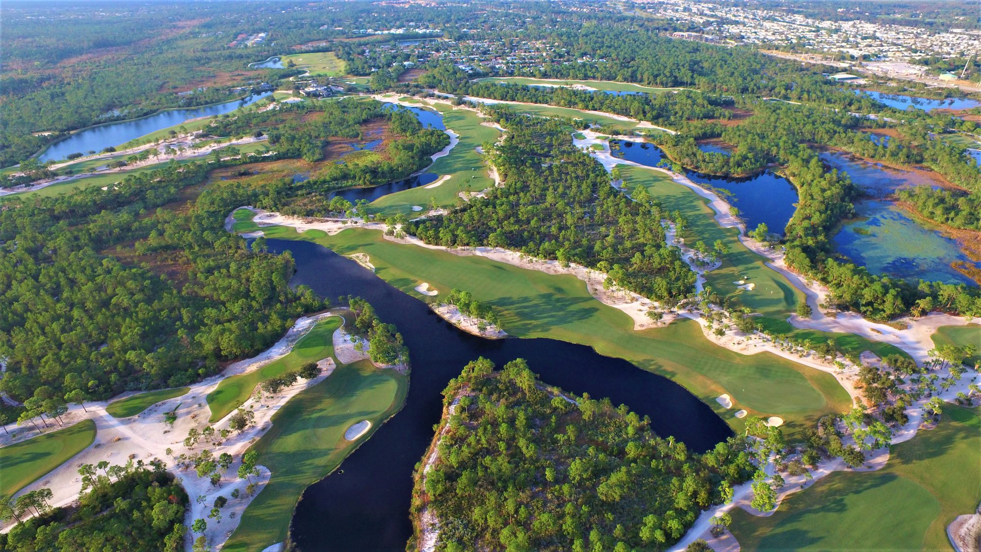 A McArthur green and fairway beside a winding lake