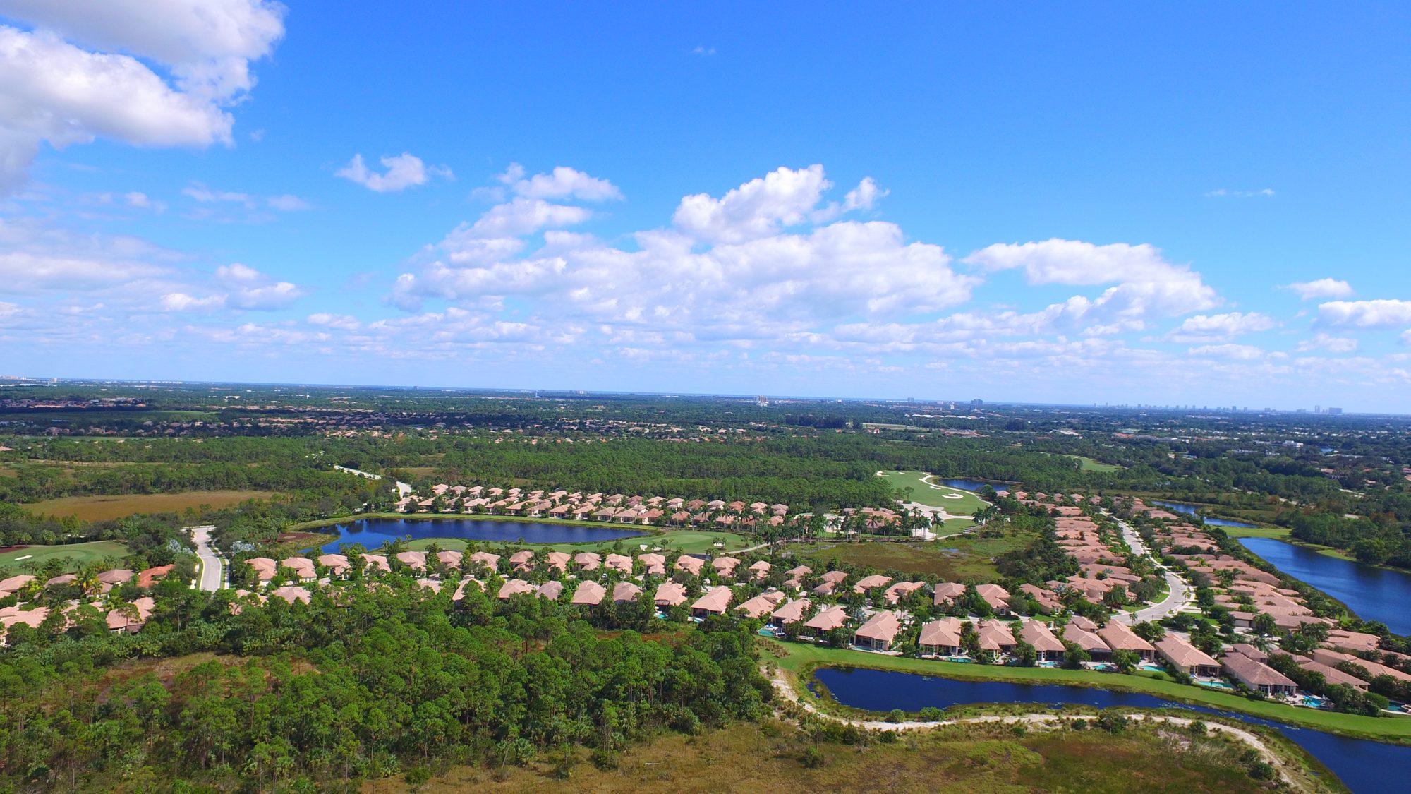 Mirasol homes along a lake and the preserve under a blue sky