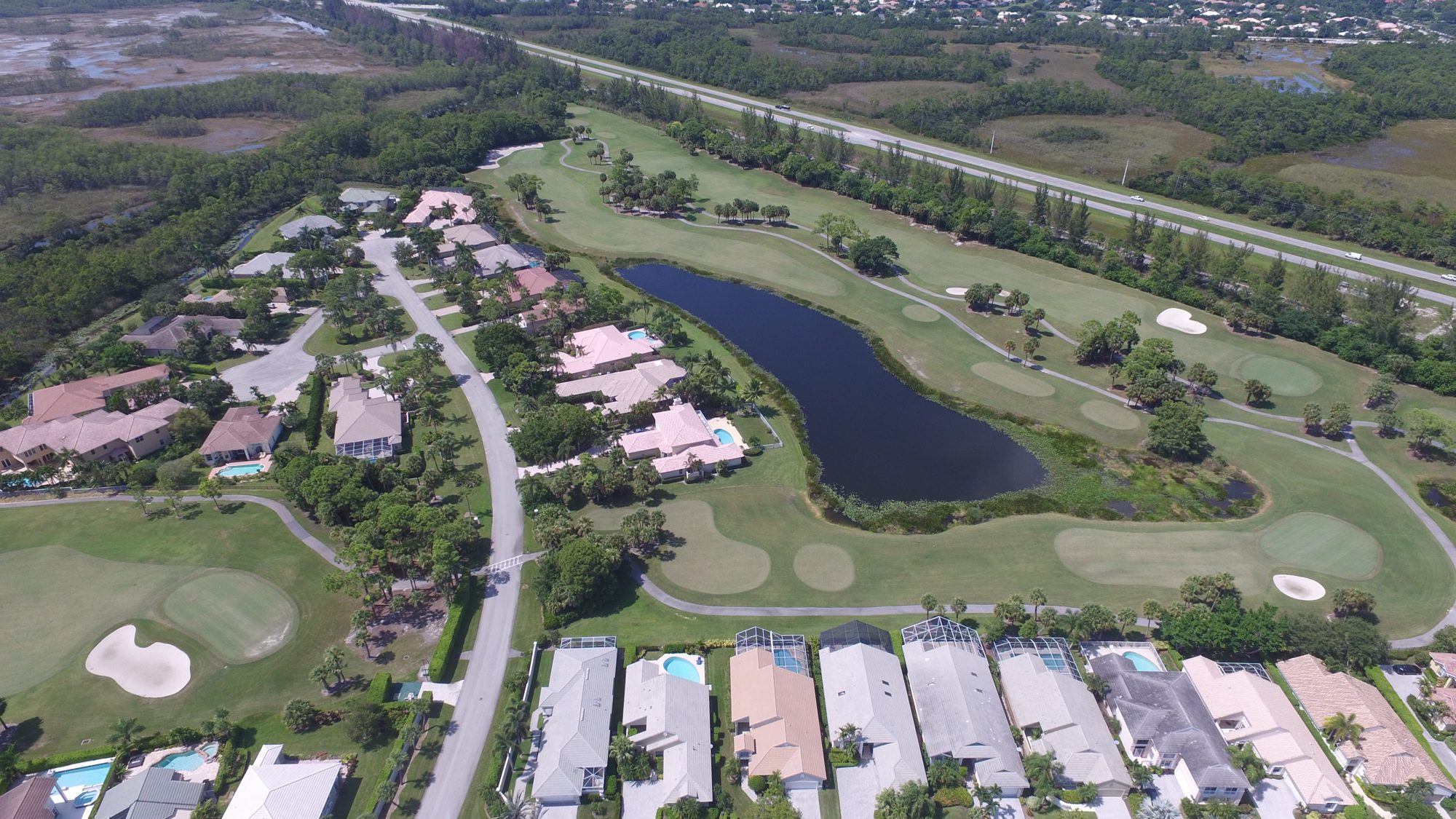 Aerial view of an Iron Horse fairway between a fountain pond and homes