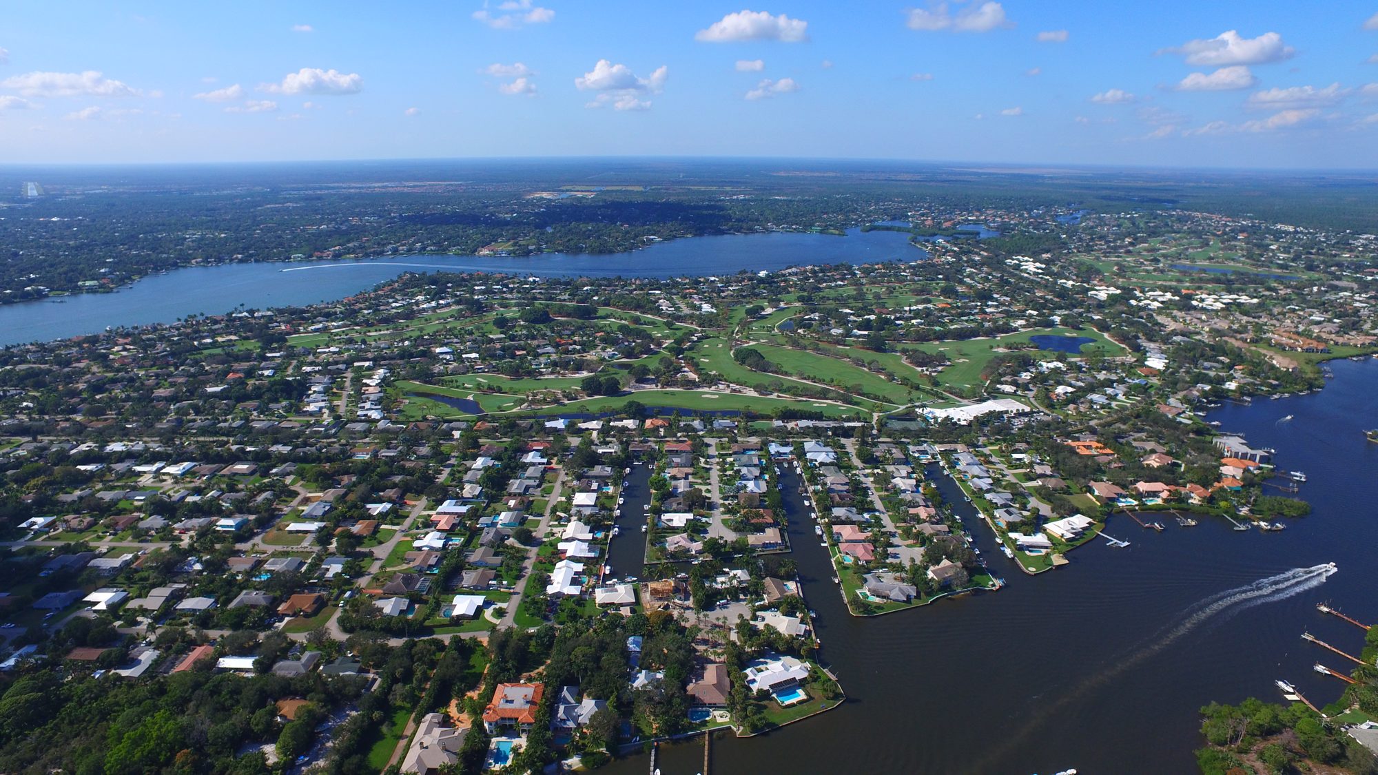 The Tequesta Country Club clubhouse, practice range and course with the Loxahatchee River beyond