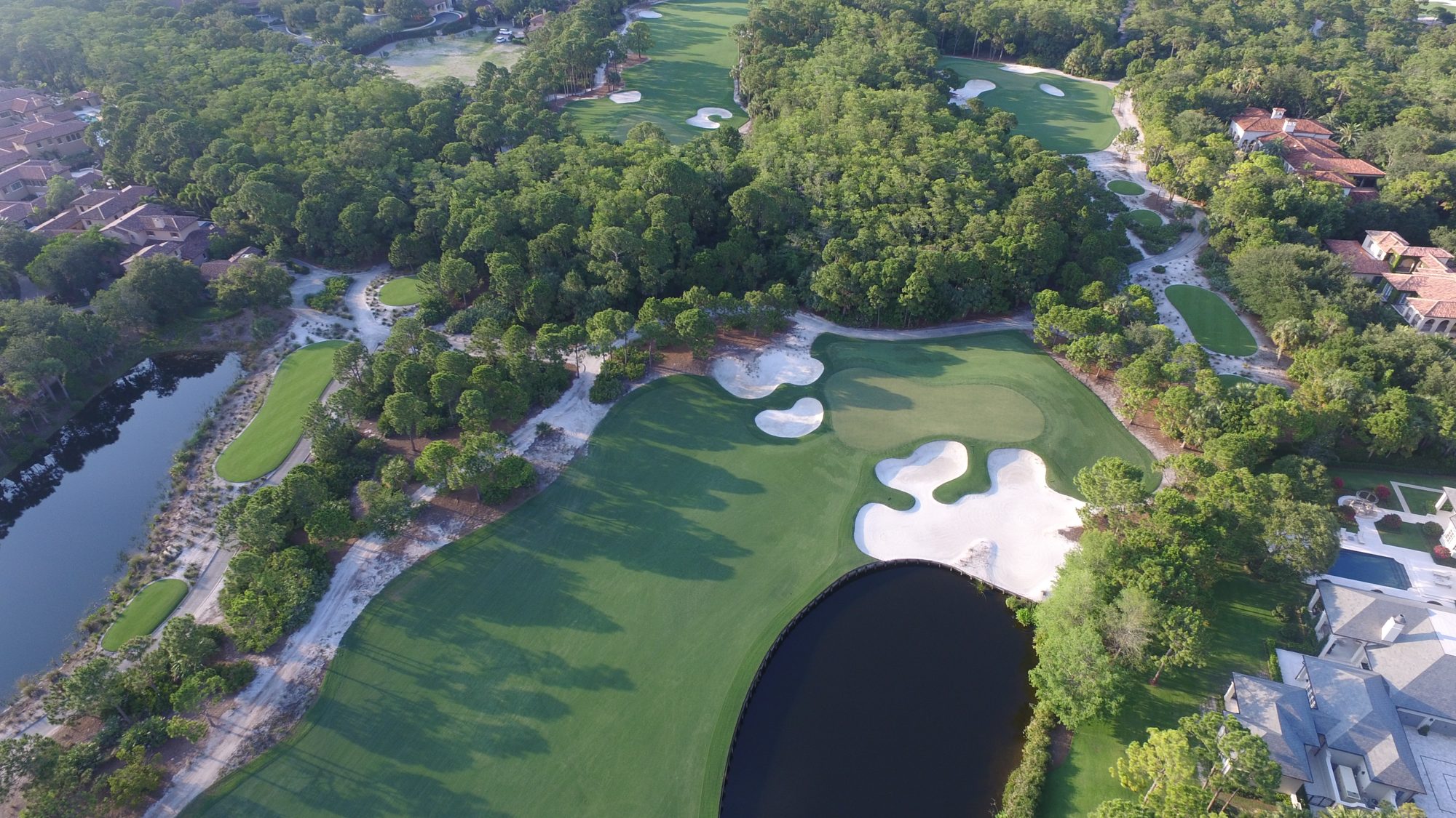 The Bears Club clubhouse beside a lake and the 18th green