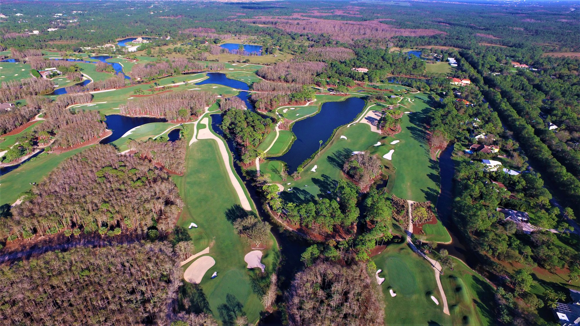 A Dye Preserve hole with a long waste bunker and grass islands beside a lake