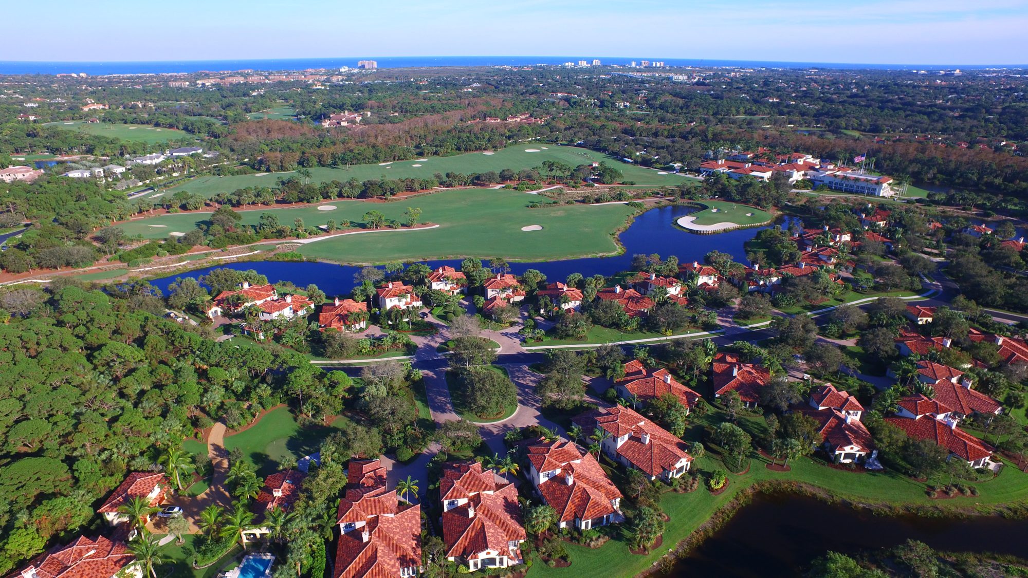 An island green and the clubhouse beyond a row of homes